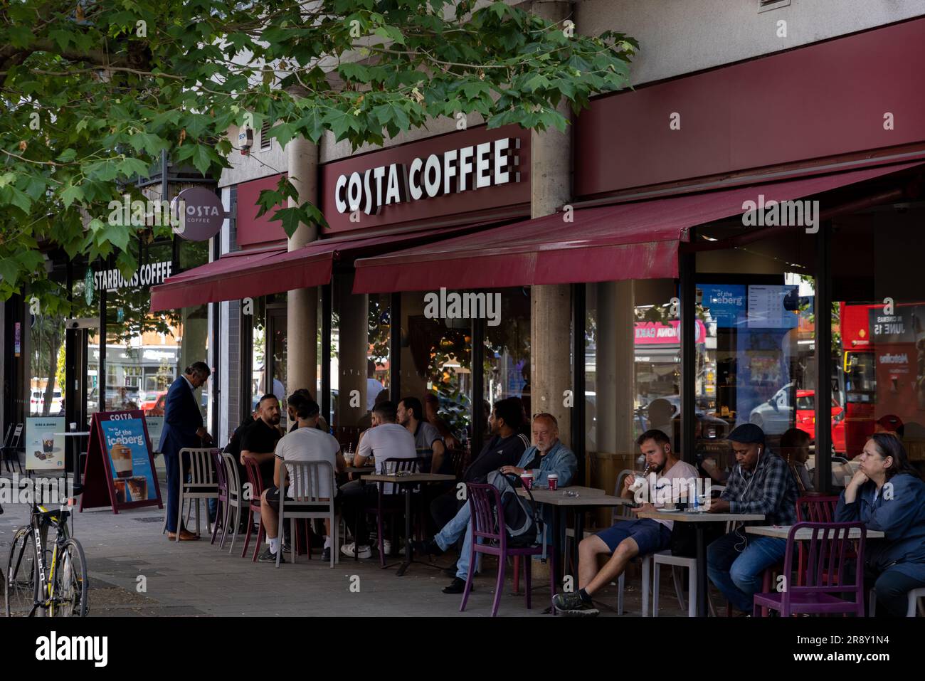 Costa und Starbucks Coffee Shops nebeneinander an einer London High Street: Uxbridge Road, Ealing Common Stockfoto