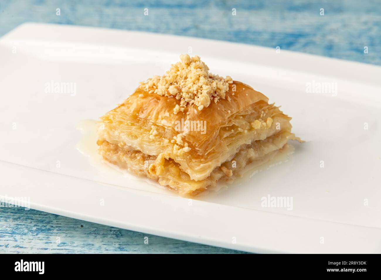 Türkische Baklava mit Haselnüssen auf einem weißen Porzellanteller Stockfoto