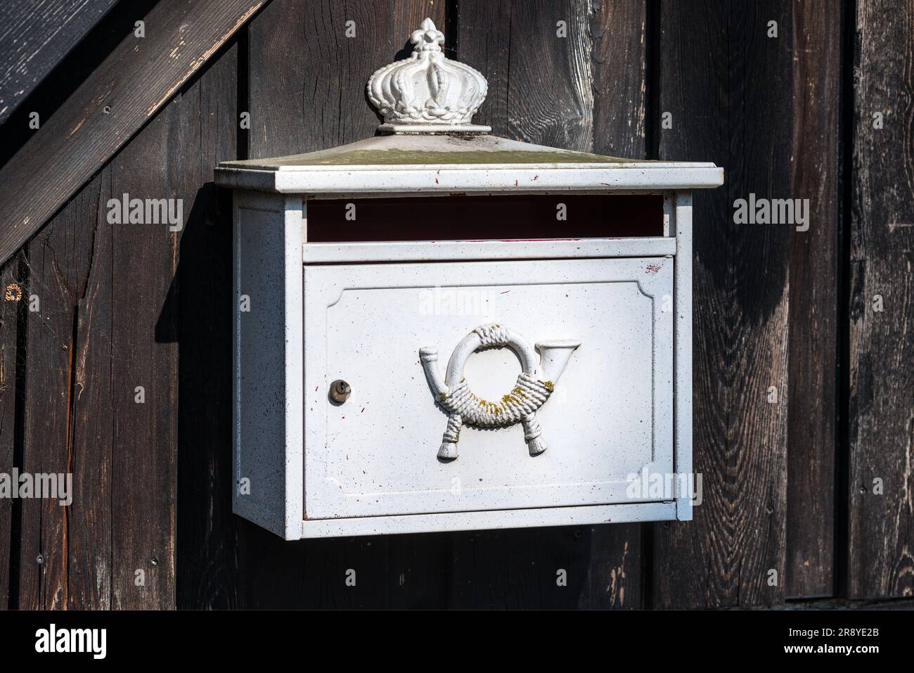 Briefkastenpostfach Metall Horn in Deutschland. Ländlicher Holzzaun - sonniger Tag. Stockfoto