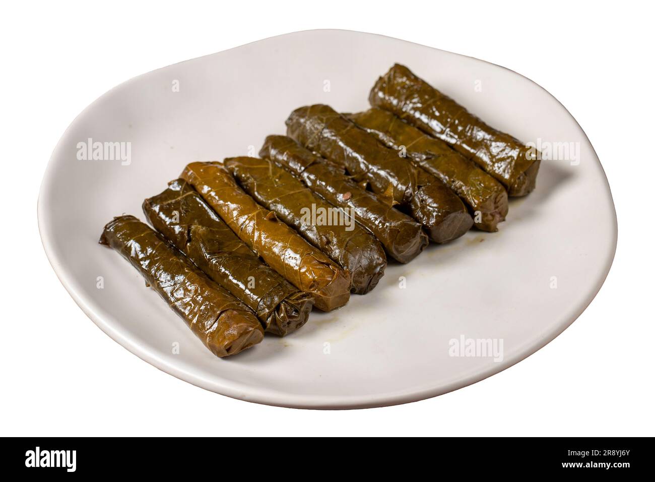 Köstliche Füllung (Yaprak Sarma). Traditionelle türkische Köstlichkeiten. Gefüllte Trauben hinterlassen Reis auf Platte isoliert auf weißem Hintergrund. Schließen Stockfoto