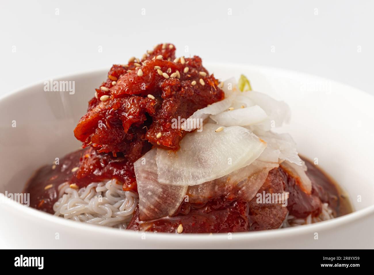 Halbtrockene Gewürzmischung Alaska pollock Naengmyeon auf weißem Hintergrund Stockfoto