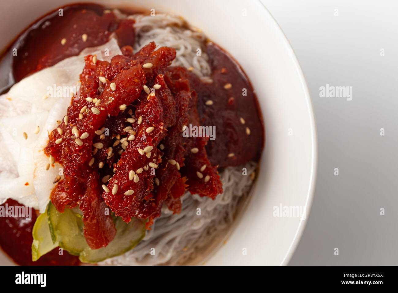 Halbtrockene Gewürzmischung Alaska pollock Naengmyeon auf weißem Hintergrund Stockfoto