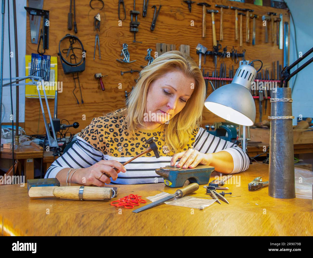 Niederlande, Goldschmiede in der Werkstatt, entwirft und arbeitet an einem Armband in ihrem Studio. Stockfoto