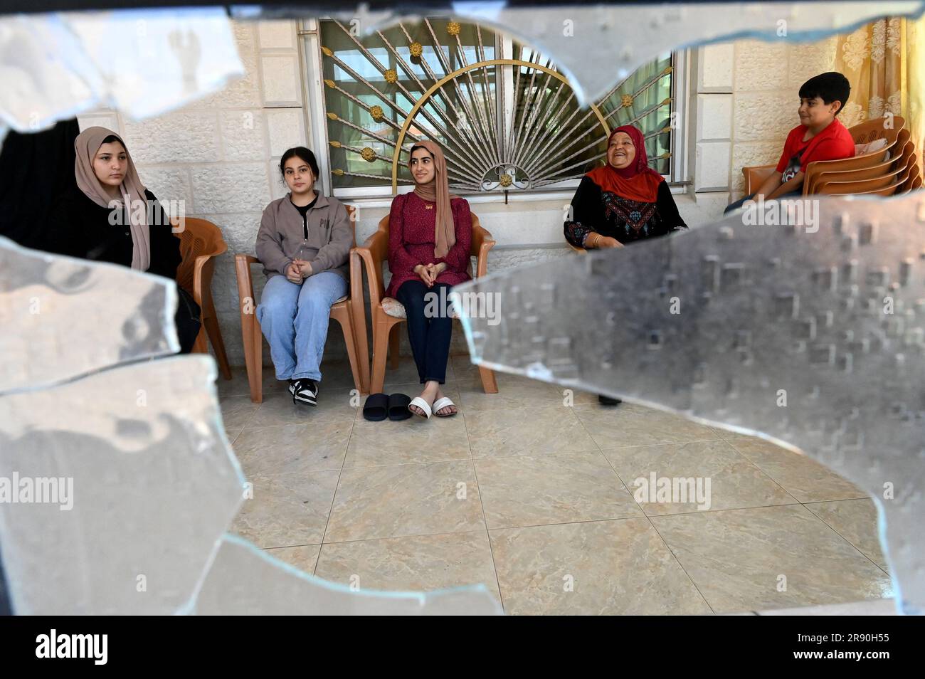 Turmus Ayya, Westjordanland. 23. Juni 2023. Die palästinensisch-amerikanische Fahmia Shalabi, 75, aus Louisiana sitzt mit Enkeln aus Kalifornien und Texas hinter Fenstern, die von israelischen Siedlern zerschmettert wurden, im Haus ihrer Familie in Turmus Ayya, Westjordanland, am Freitag, den 23. Juni 2023. Hunderte maskierter und bewaffneter israelischer Siedler wüteten am Mittwoch im friedlichen Dorf Turmus Ayya, wo sie Autos und Häuser von Palästinensern in einem Racheangriff verbrannten, nachdem vier Israelis von palästinensischen Schützen erschossen wurden. Foto von Debbie Hill/ Kredit: UPI/Alamy Live News Stockfoto