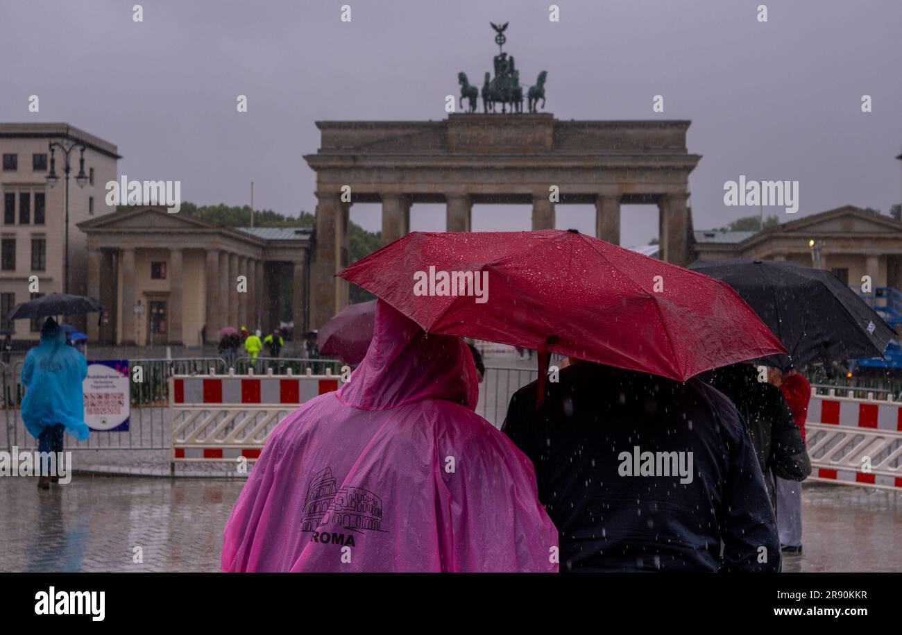 23. Juni 2023, Berlin: Im strömenden Regen stehen Touristen mit Regenschirmen und Regenponchos vor dem Brandenburger Tor. Foto: Monika Skolimowska/dpa Stockfoto