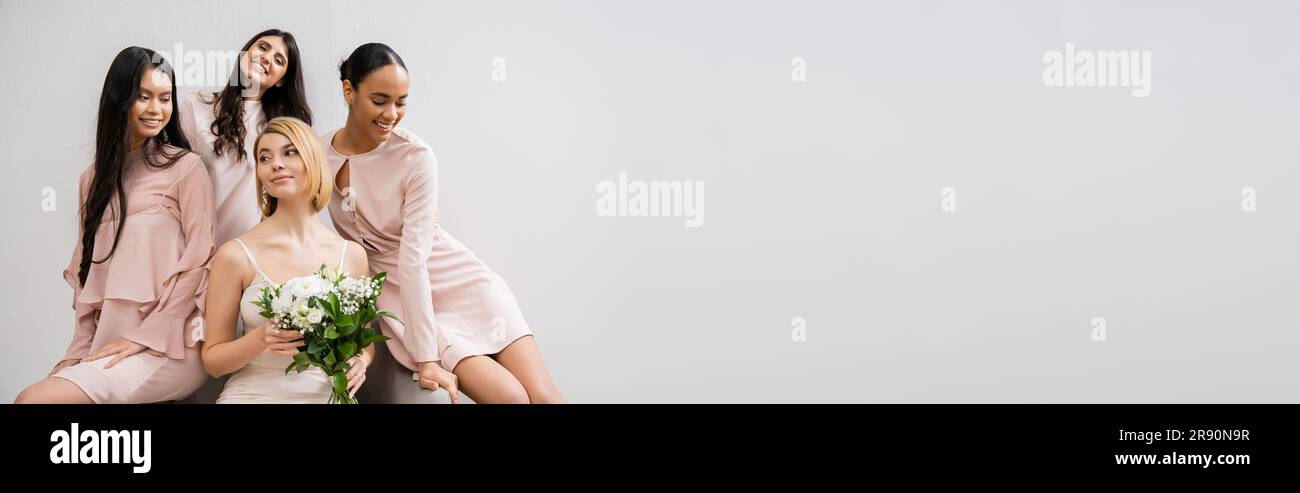 Hochzeitsfotografie, vier Frauen, Braut mit Brautjungfern, gemischtrassig, Hochzeitstag, kulturelle Vielfalt, auf einem Sessel sitzen, Graue Hintergrundfarbe Stockfoto Hochzeitsfotografie, vier Frauen, Braut mit Brautjungfern, gemischtrassig, Hochzeitstag, kulturelle Vielfalt, auf einem Sessel sitzen, Graue Hintergrundfarbe Stockfoto