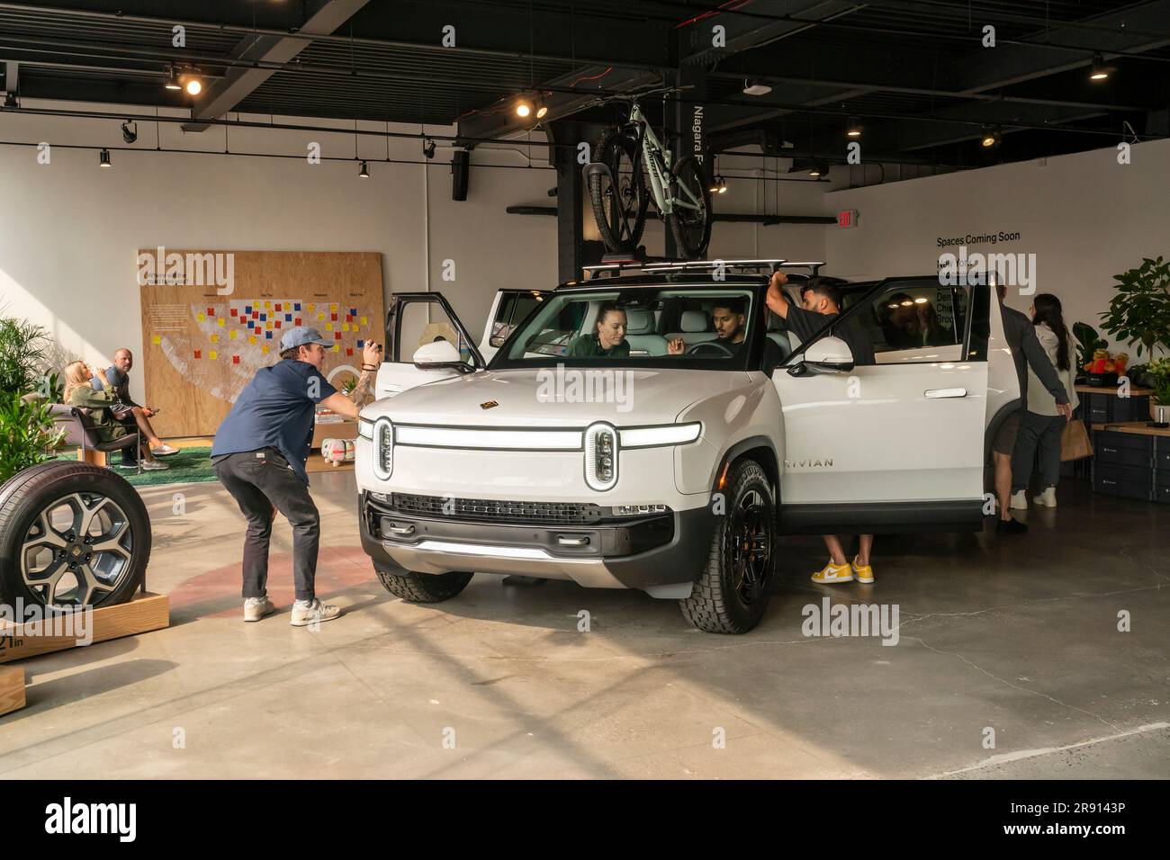 Automobil-Enthusiasten nehmen am Freitag, den 16. Juni 2023, an der Eröffnung eines Ausstellungsraums im Meatpacking District in New York Teil. Rivian hat sich im Meatpacking District mit anderen Herstellern von Luxus-Elektrofahrzeugen wie Tesla, Genesis und Lucid zusammengetan. (© Richard B. Levine) Stockfoto