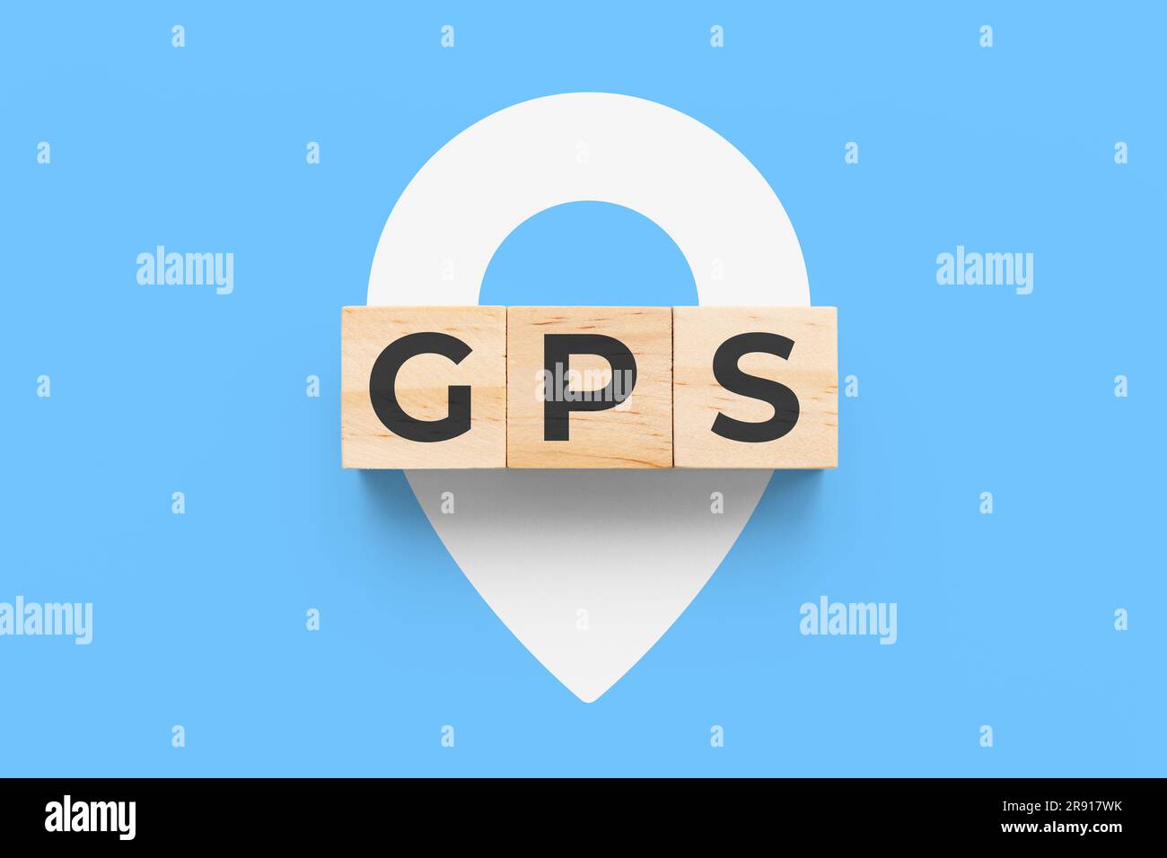 GPS-Holzwürfel (Global Positioning System) auf blauem Hintergrund mit weißem Stiftsymbol Stockfoto