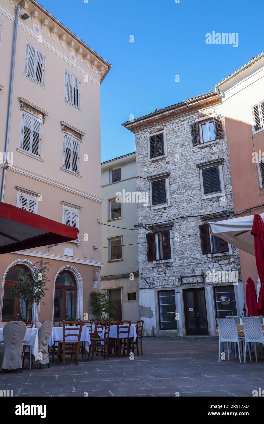 Pula, Kroatien - 21. August 2022: Straßenblick mit Restaurant am Sommermorgen. Gebäude der europäischen Architektur mit blauem Himmel in Istrien. Stockfoto