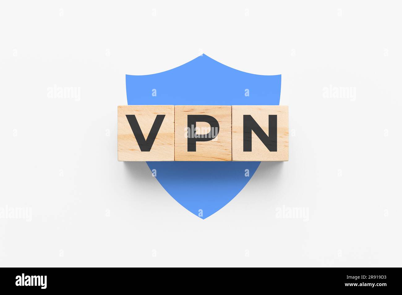 VPN-Holzwürfel (Virtual Private Network) auf weißem Hintergrund mit blauem Schildsymbol Stockfoto