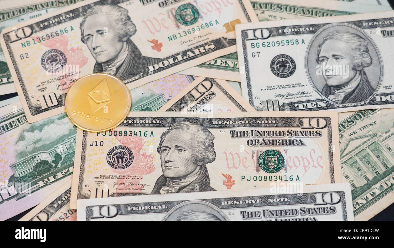 Ethereum (Ether) ETH-Kryptowährung, dargestellt als Goldmünze, die über Bargeld-Dollar liegt, echtes US-Geld, 50 Dollar, US-Dollar-Schein Stockfoto