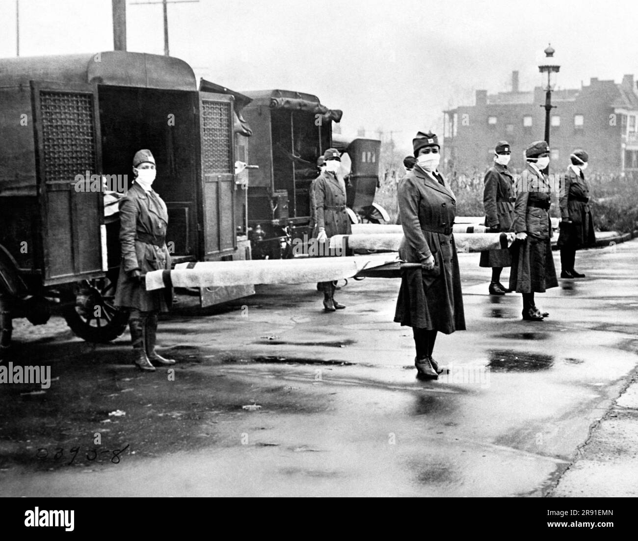 St. Louis, Missouri: Oktober 1918, The St. Louis Red Cross Motor Corps im Dienst mit maskentragenden Frauen, die während der Grippeepidemie Bahren an den Rücken von Krankenwagen halten. Stockfoto