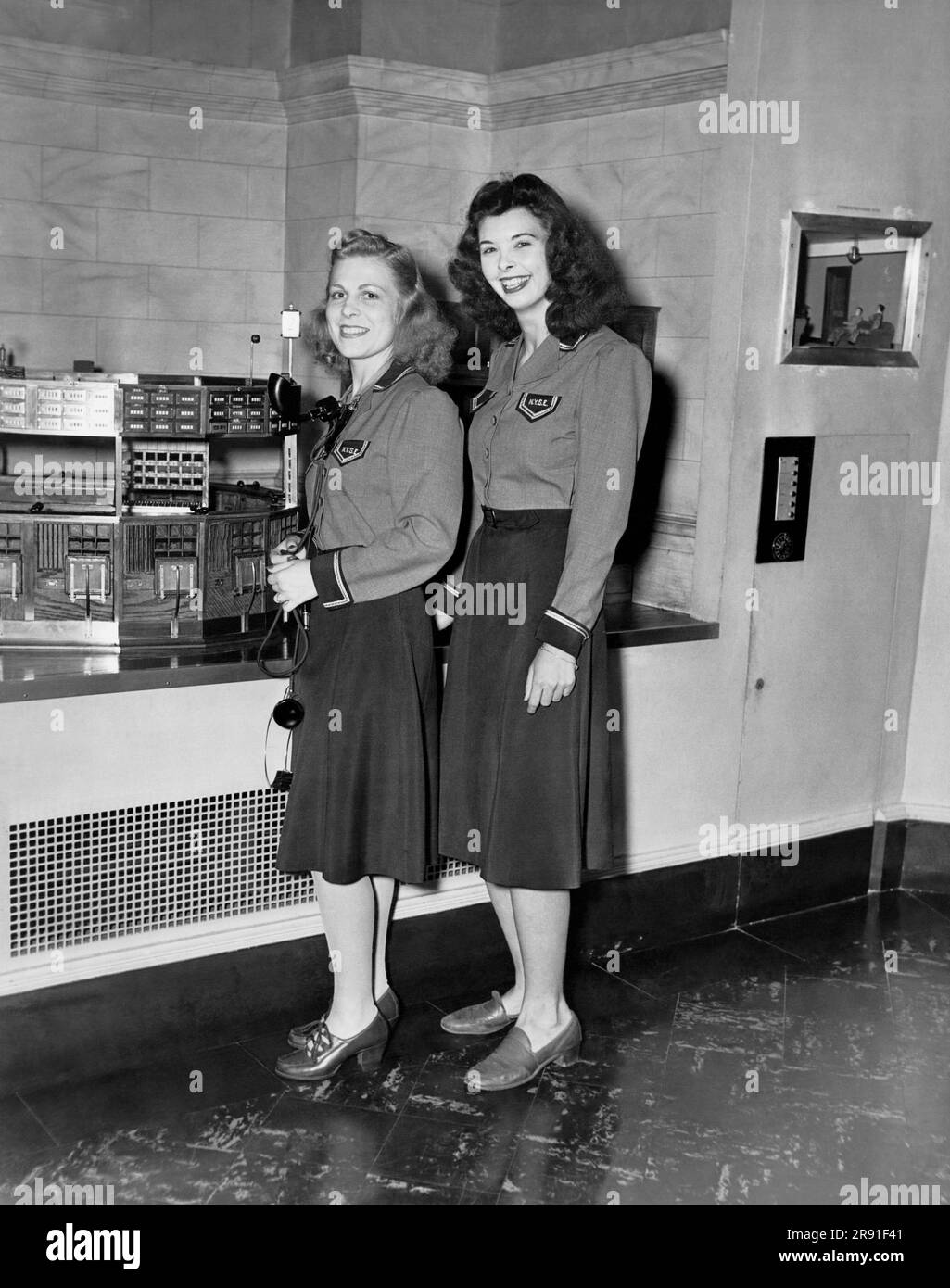 New York, New York: ca. 1943 Frauen waren während des Krieges an der NY-Börse angestellt, um die Männer in Übersee zu vertreten. Diese beiden sind Transportdienstleister, die Anweisungen erhalten. Stockfoto