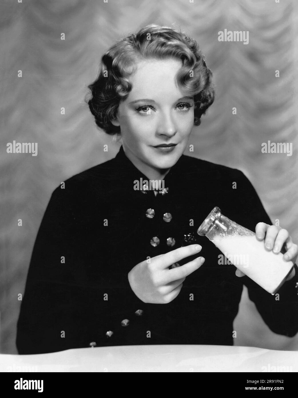 Hollywood, Kalifornien: c. 1934 Fox Film Schauspielerin Rosemary Ames verwendet eine milchgefüllte Augenmuschel, um ihre Augen nach einem anstrengenden Tag am Set zu beruhigen. Stockfoto