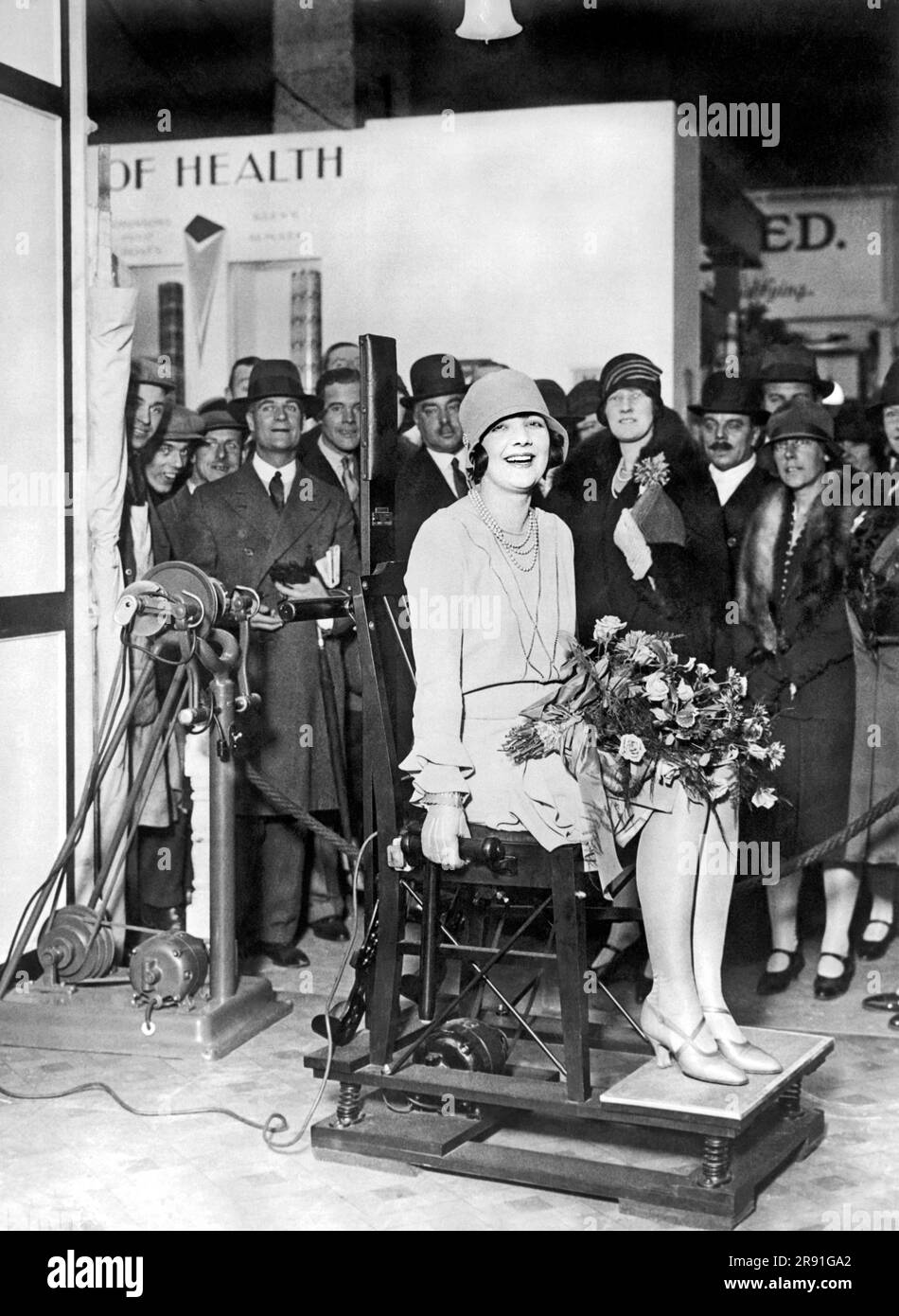 London, England: ca. 1927. Queenie Thomas, britische Filmspielerin, demonstriert den Vibrationsstuhl auf der New Health Exhibition in Westminster. Der Stuhl soll für alle nervösen Probleme ausgezeichnet sein. Stockfoto