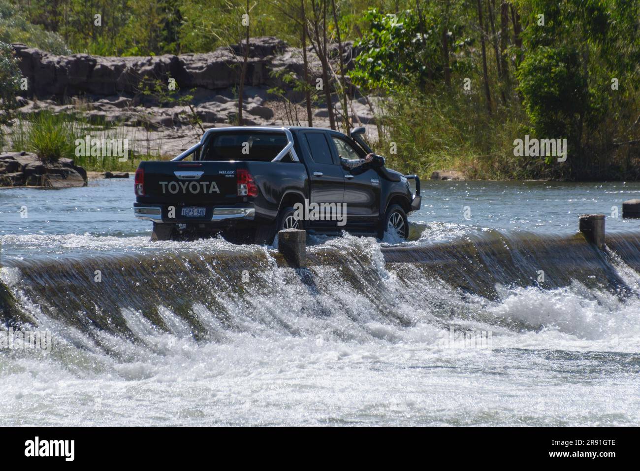 Ein Pick-up-Truck oder Ute, der das fließende Wasser des Ord auf der Ivanhoe-Kreuzung in der Nähe von Kununurra im Westen Australiens überquert Stockfoto
