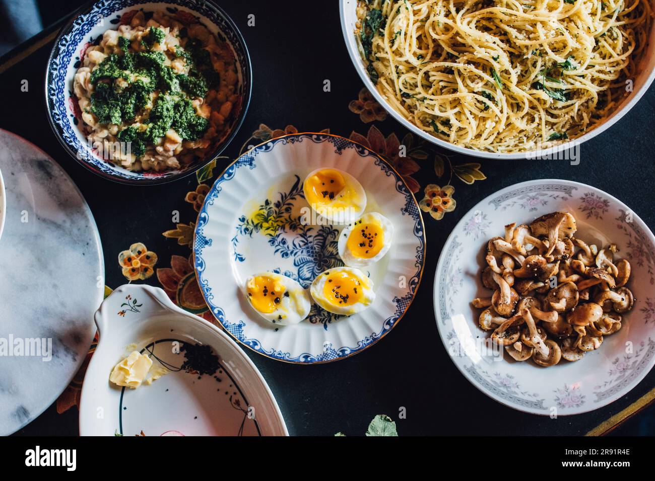 Top-down-Schuss Essen auf dem Tisch für die Party mit Eiern, Nudeln, Pilzen, Bohnen, Radieschen, Frühlingsessen Stockfoto