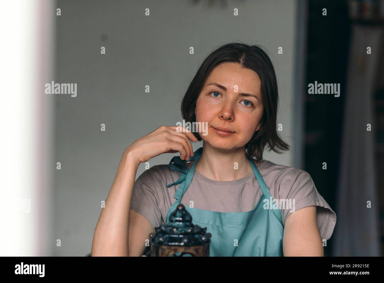 Potter mit kurzen Haaren und Schürze in der Werkstatt Stockfoto