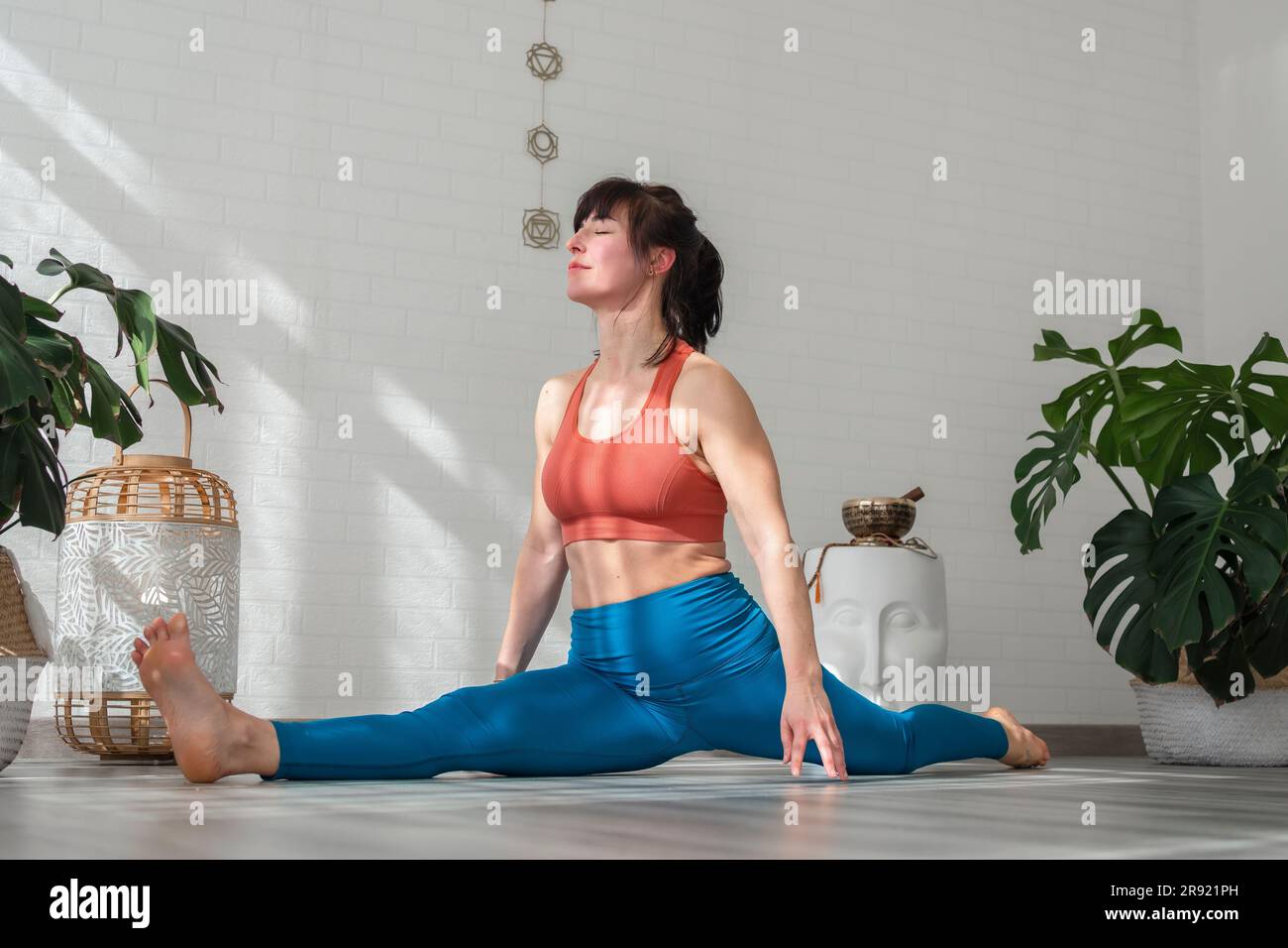 Reife Frau, die Yoga praktiziert und Split macht Stockfoto