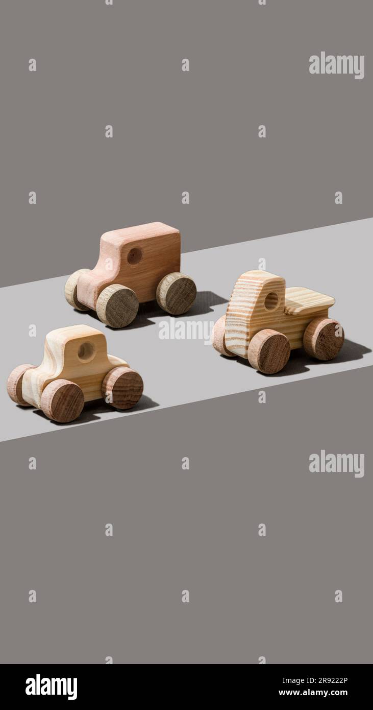 Spielzeugautos aus Holz auf grauem Hintergrund Stockfoto
