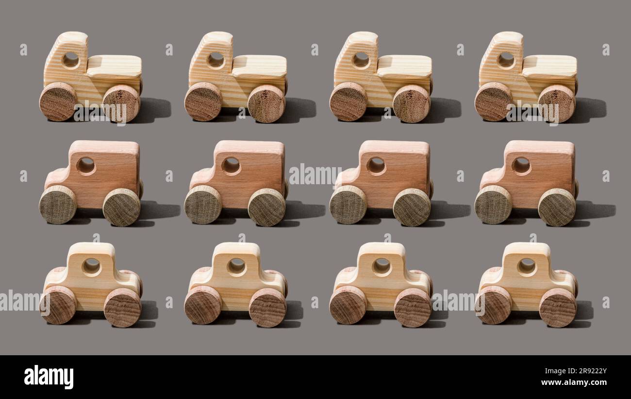 Spielzeugautos aus Holz auf grauem Hintergrund Stockfoto