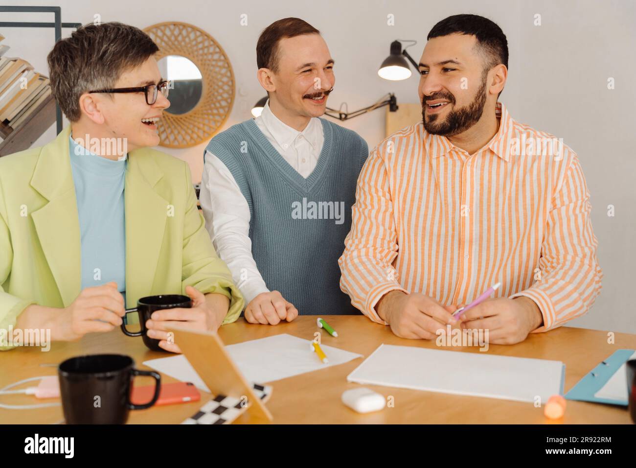 Kollegen lachen und reden miteinander im Studio Stockfoto