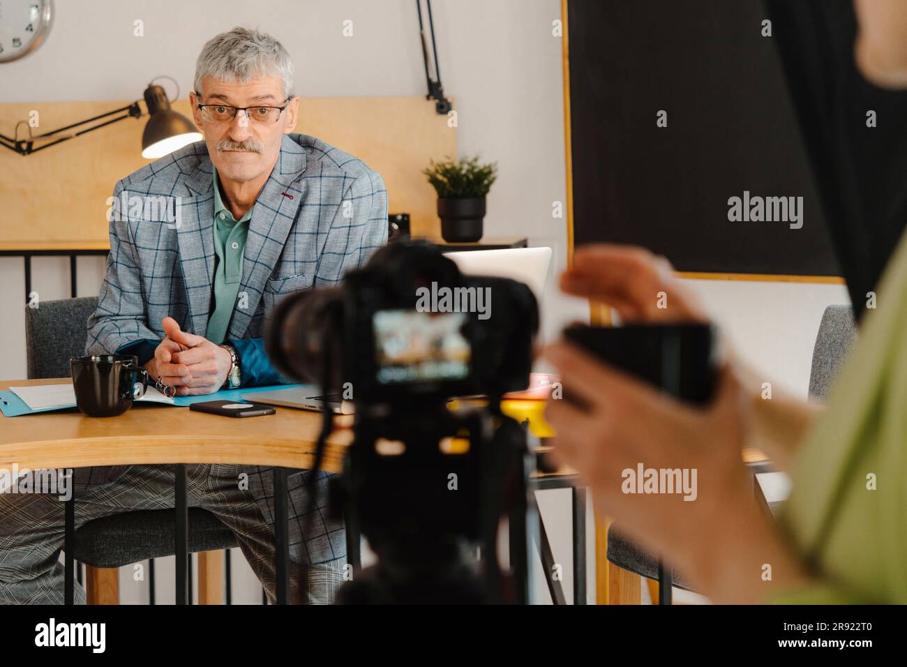 Frau, die einen männlichen Kollegen filmt, der einen Online-Kurs hat Stockfoto