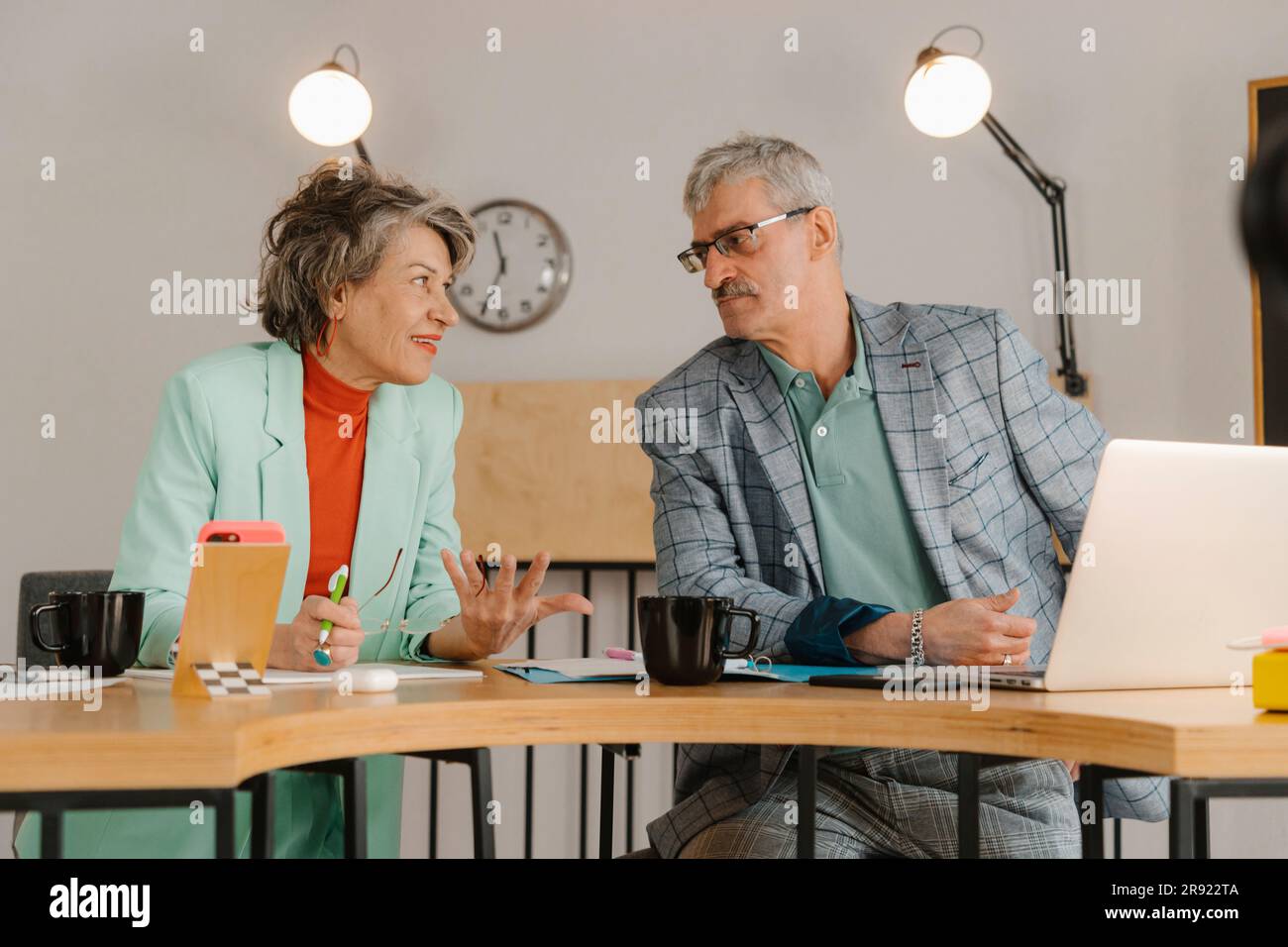 Geschäftsmann und Geschäftsfrau kommunizieren im Studio Stockfoto