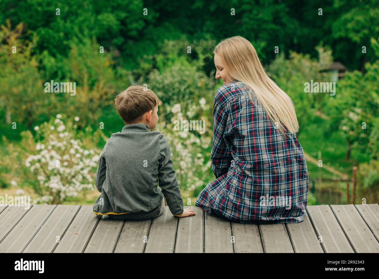 Glückliche Mutter mit Sohn, die Zeit zusammen im Garten verbringen Stockfoto