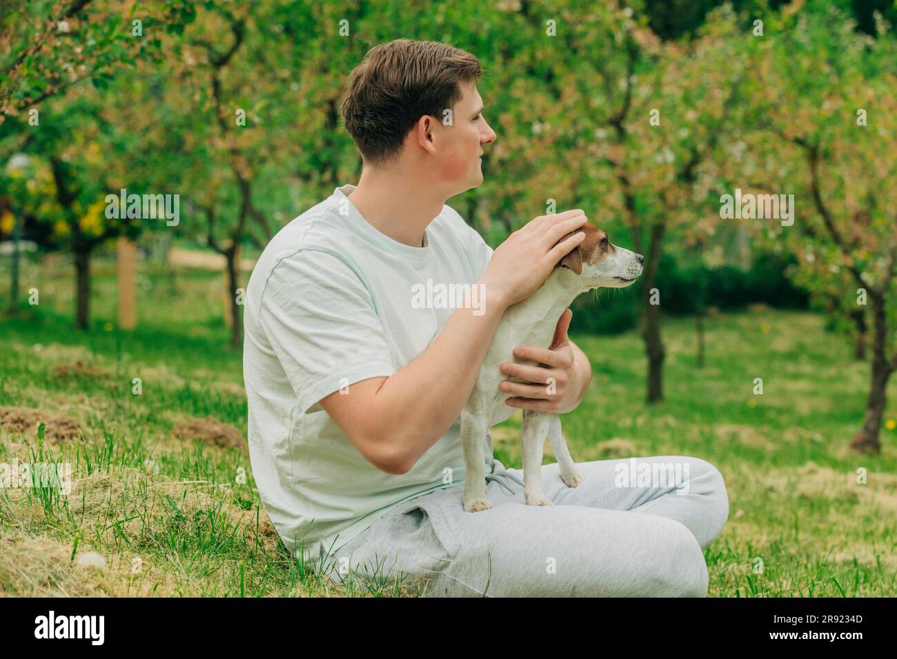 Mann sitzt mit Jack Russell Terrier Hund im Garten Stockfoto