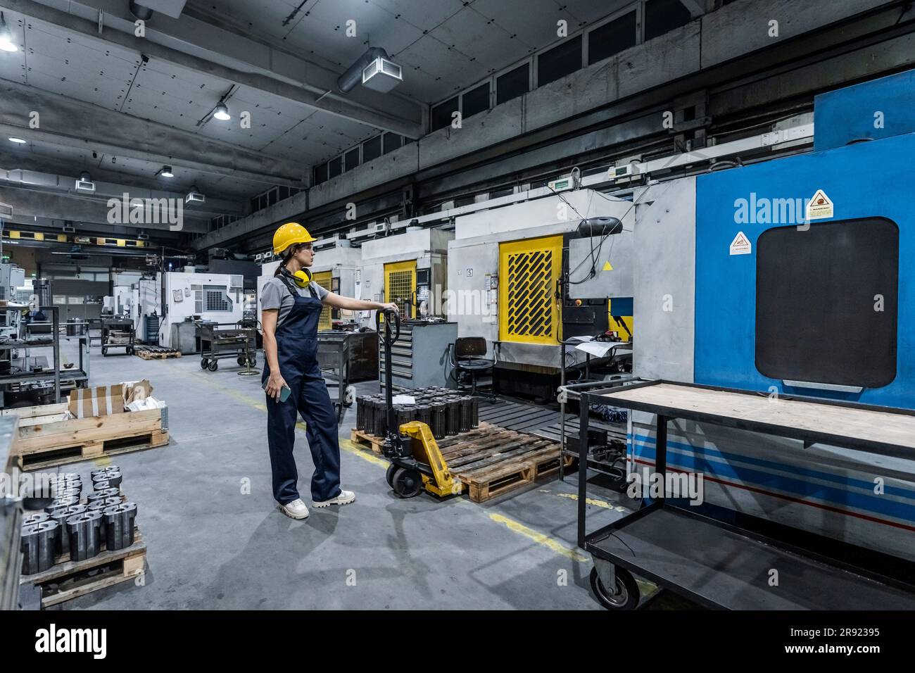 Wartungstechniker steht in einer modernen Fabrik neben dem Gabelstapler Stockfoto