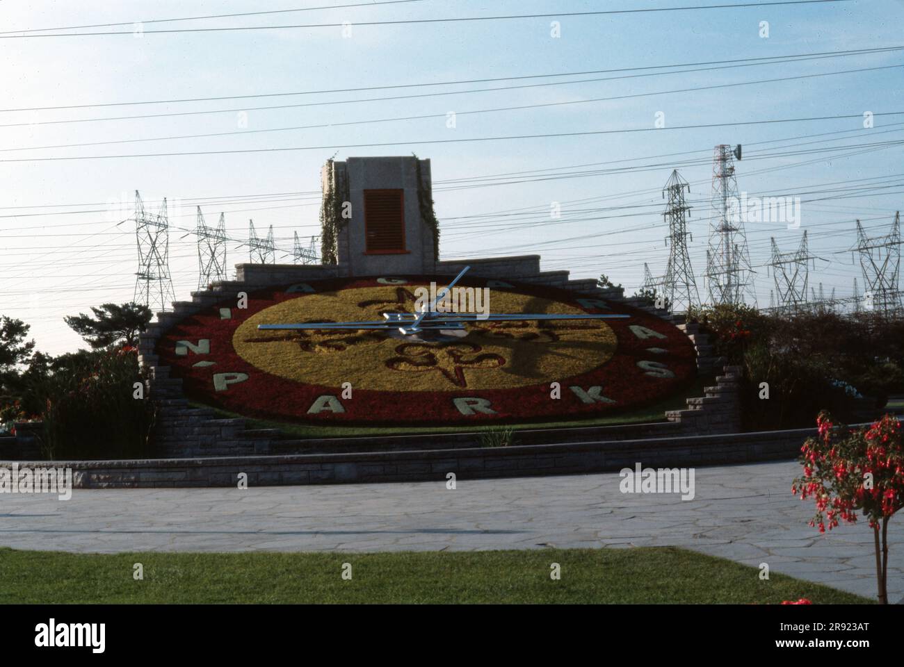 Niagara-on-the-Lake, Ontario, Kanada- September 1978: Blick auf die Niagara Parks Blumenuhr mit Stromleitungen im Hintergrund. Stockfoto Niagara-on-the-Lake, Ontario, Kanada- September 1978: Blick auf die Niagara Parks Blumenuhr mit Stromleitungen im Hintergrund. Stockfoto