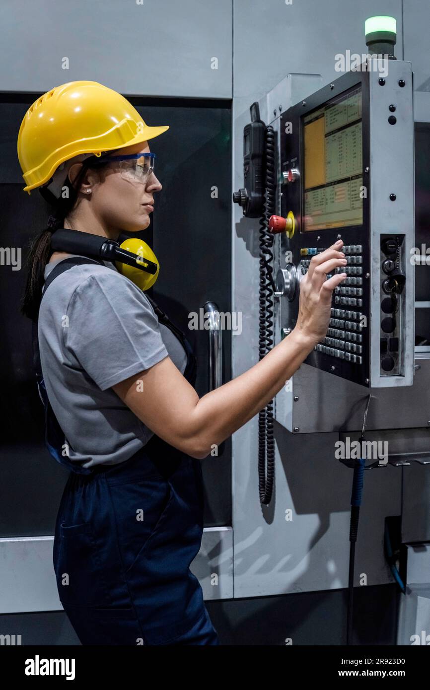 Wartungstechniker, der die CNC-Tastatur im Werk bedient Stockfoto