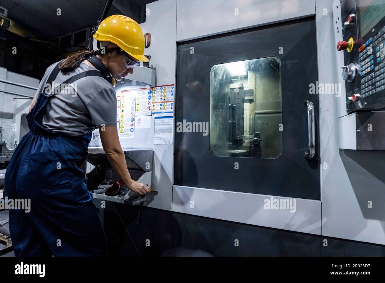 Wartungstechniker, der in einem modernen Werk an der CNC-Maschine arbeitet Stockfoto