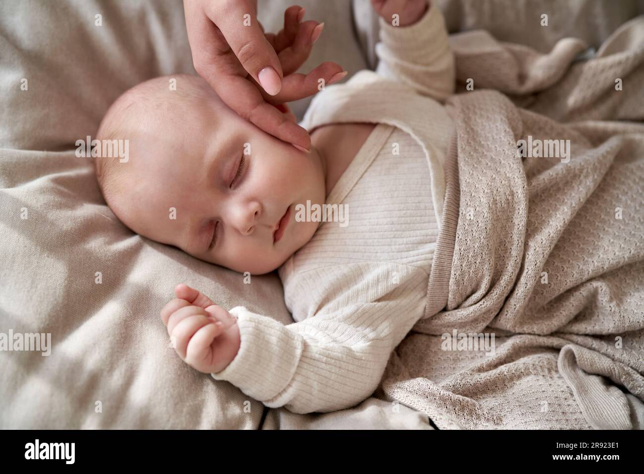 Mutter streichelt die Wange eines kleinen Mädchens, das zu Hause schläft Stockfoto