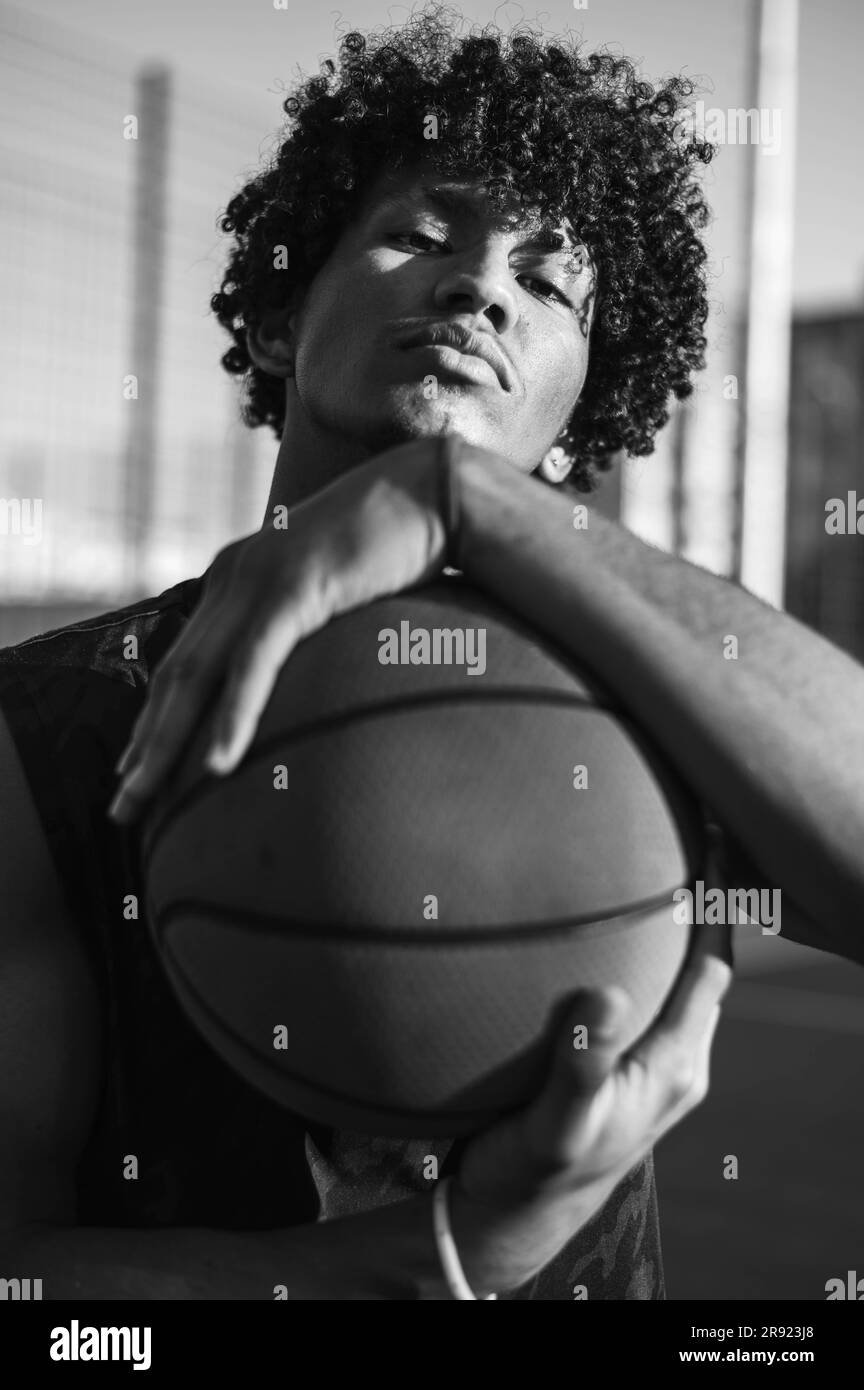 Selbstbewusster junger Sportler, der Basketball in den Händen hält Stockfoto