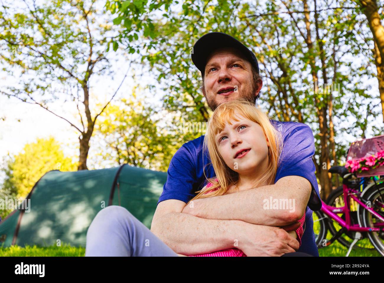Glücklicher Vater, der seine Tochter im Zelt umarmt Stockfoto