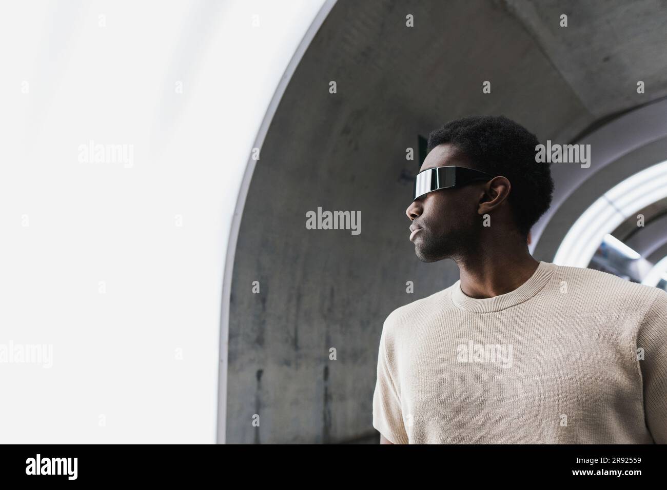 Futuristischer Mann mit Cyber-Brille, der auf die Lichtscheibe schaut Stockfoto