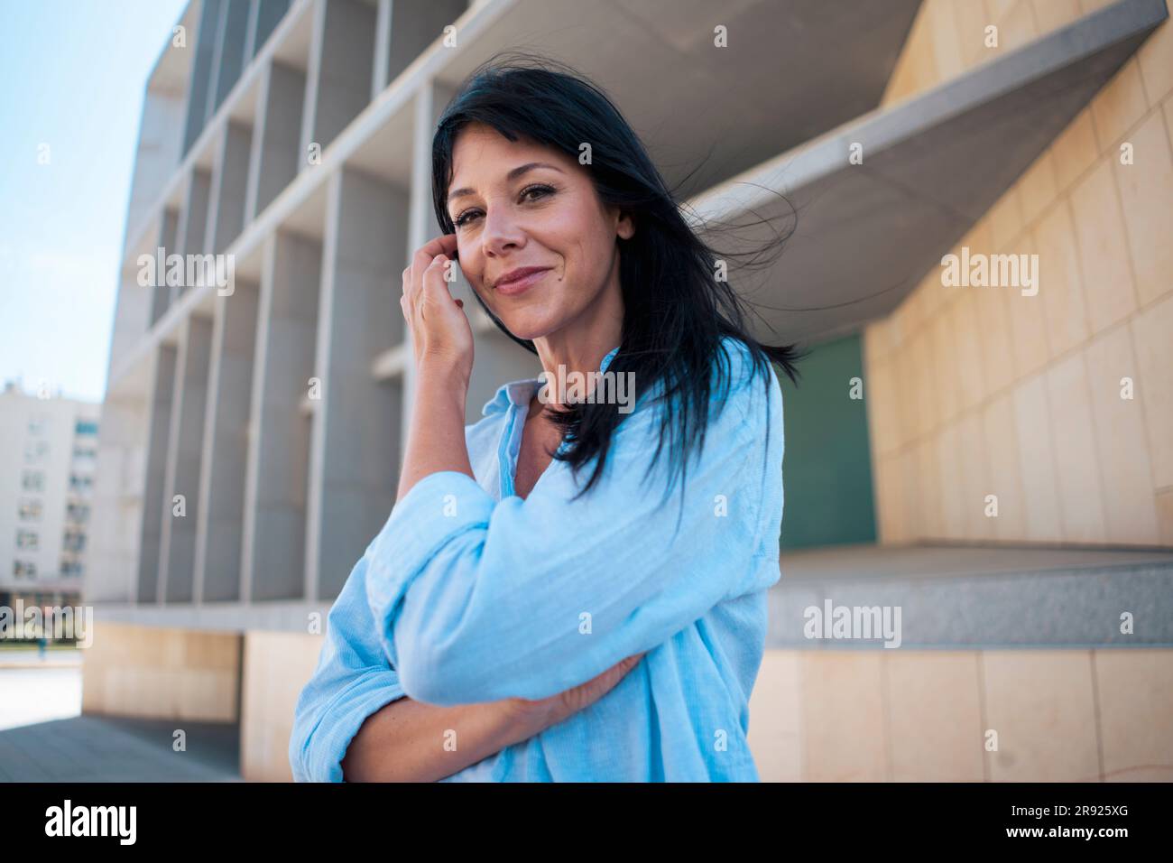 Lächelnde Geschäftsfrau mit Hand im Haar Stockfoto