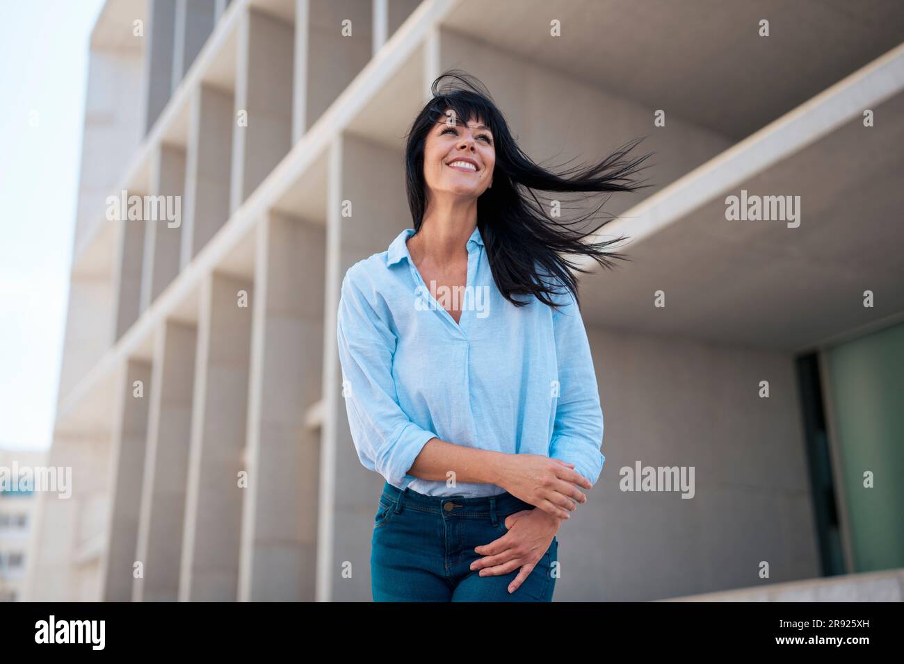 Lächelnde Geschäftsfrau vor dem Gebäude Stockfoto