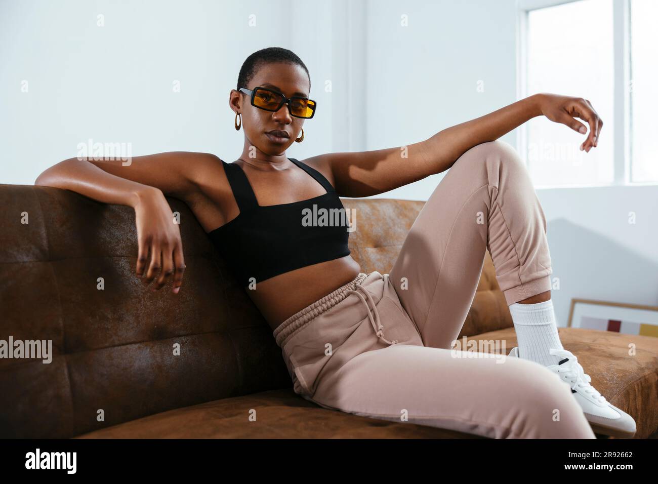 Junge Frau mit kurzen Haaren, entspannt auf dem Sofa Stockfoto
