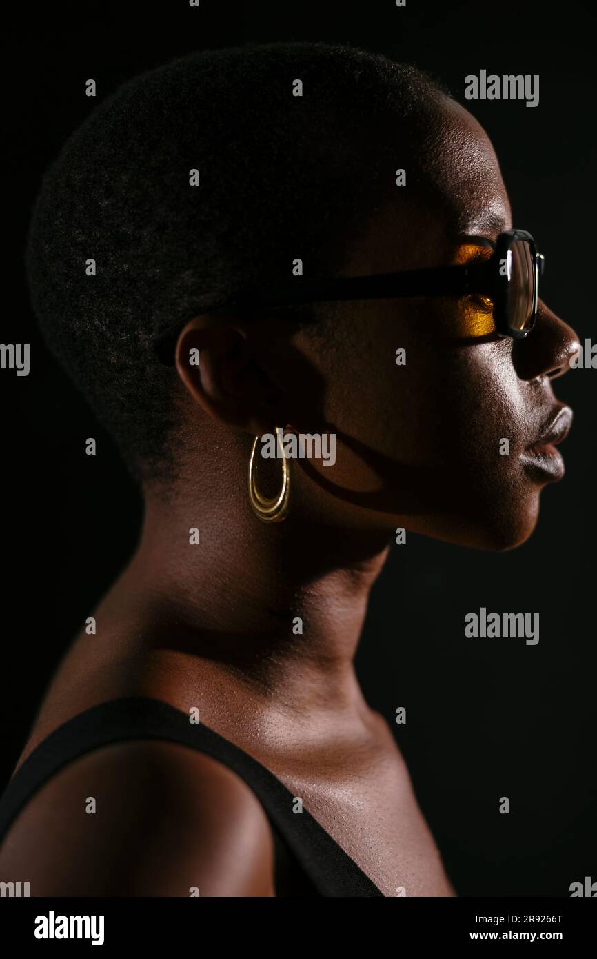 Junge Frau mit kurzen Haaren vor schwarzem Hintergrund Stockfoto