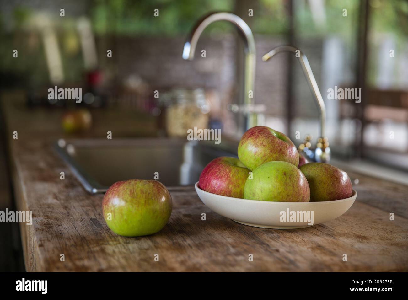 Schüssel mit Äpfeln auf einer hölzernen Küchentheke Stockfoto