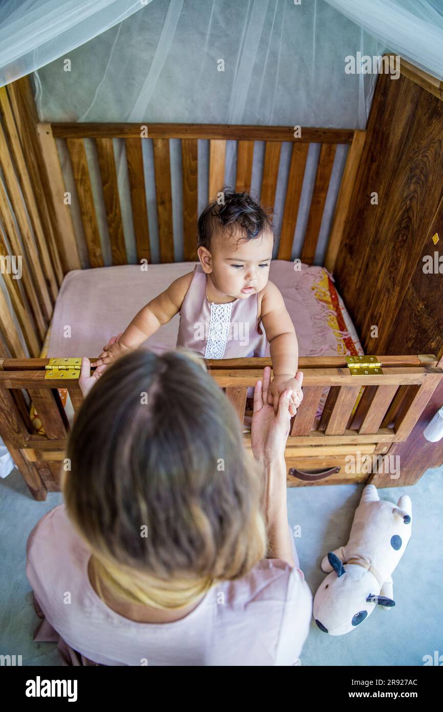 Mutter mit Tochter spielt zu Hause im Kinderbett Stockfoto