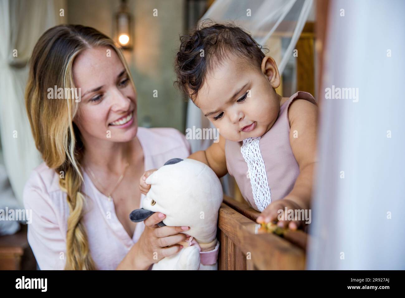 Glückliche Mutter mit kleiner Tochter, die zu Hause spielt Stockfoto