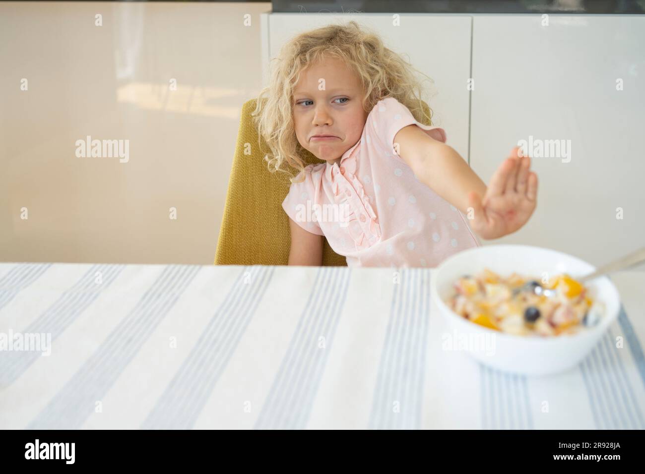 Ein Mädchen weigert sich, am Tisch zu frühstücken Stockfoto