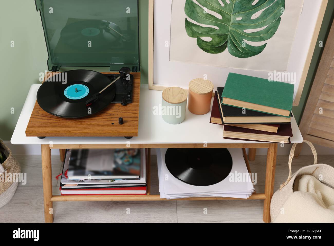 Eleganter Plattenspieler mit Konsolentisch aus Vinyl-Schallplatten im Zimmer Stockfoto