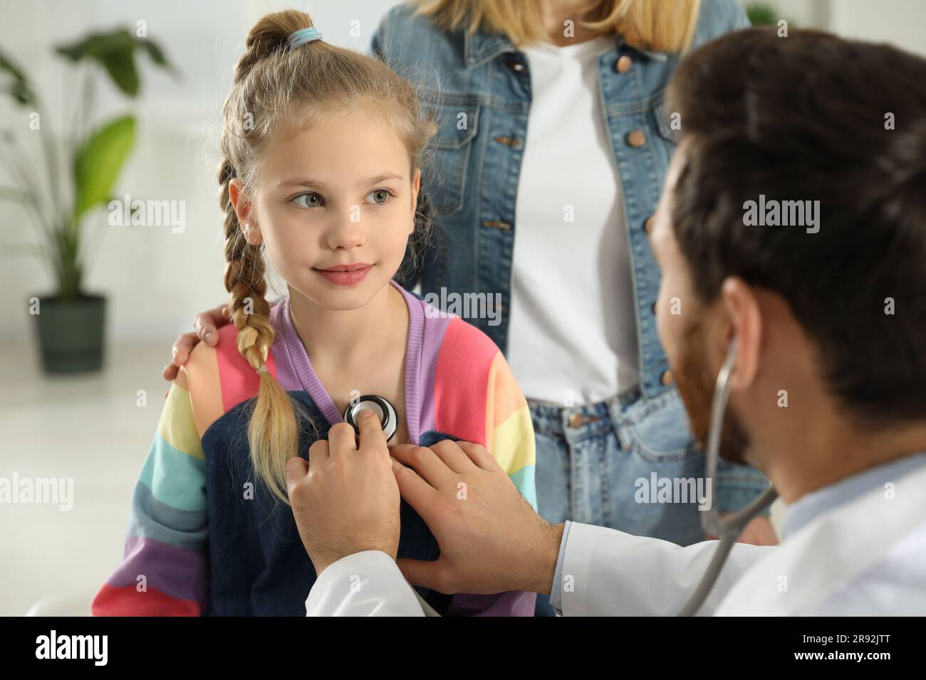 Mutter und Tochter haben einen Arzttermin. Kinderarzt untersucht Patienten mit Stethoskop in der