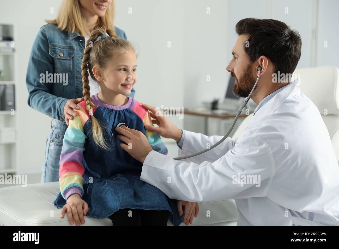 Mutter und Tochter haben einen Arzttermin. Kinderarzt untersucht Patienten mit Stethoskop in der
