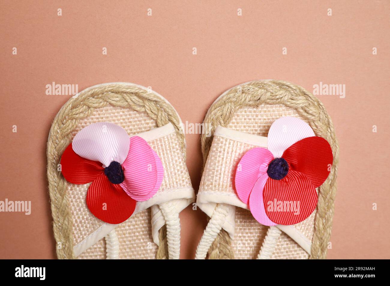 Süße Babyschuhe auf braunem Hintergrund, flach liegend Stockfoto